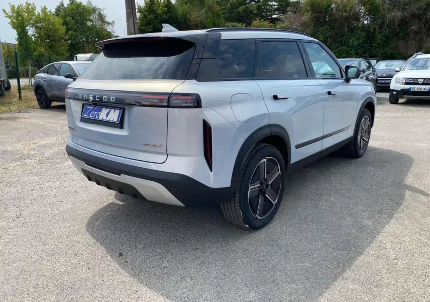 Vue 3/4 arrière droite du SUV JAECOO J7 argent Moonlight avec toit noir et vitres arrière surteintées.