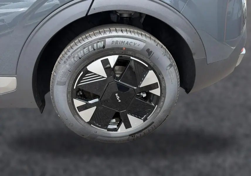 Gros plan sur la roue arrière droite gris eclipse du Kia Sportage 1.6 hybride 239 avec jante alu noire et argentée.
