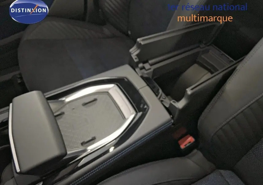 Vue rapprochée de la console centrale avec accoudoir ouvert et sièges en cuir noir et tissu bleu du Renault Rafale 2024.