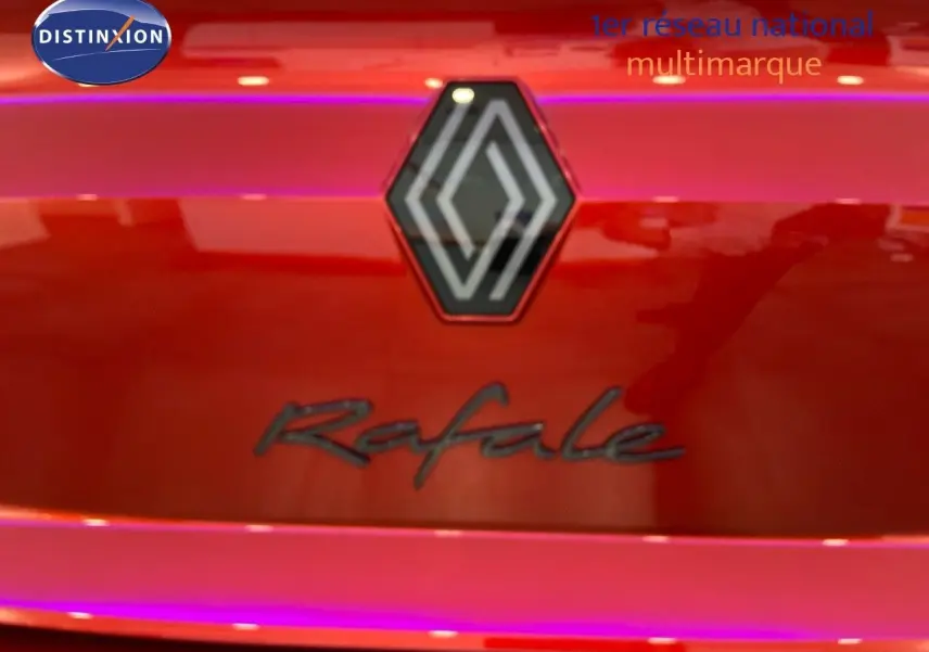 Gros plan sur le logo Renault et l'inscription Rafale sur la malle arrière rouge flamme métal du véhicule.