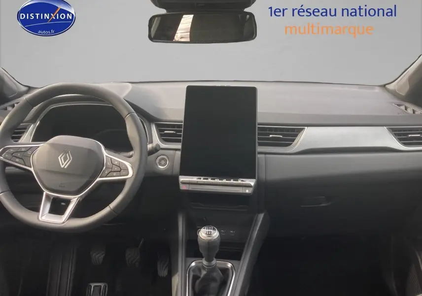 Vue frontale de l'intérieur du Renault Captur bleu iron 2025, avec volant multifonction et écran tactile vertical.