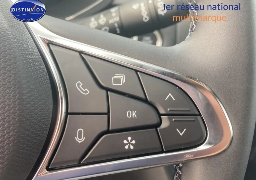 Gros plan sur les commandes multifonctions noires du volant du Renault Captur Bleu Iron, version 2025.