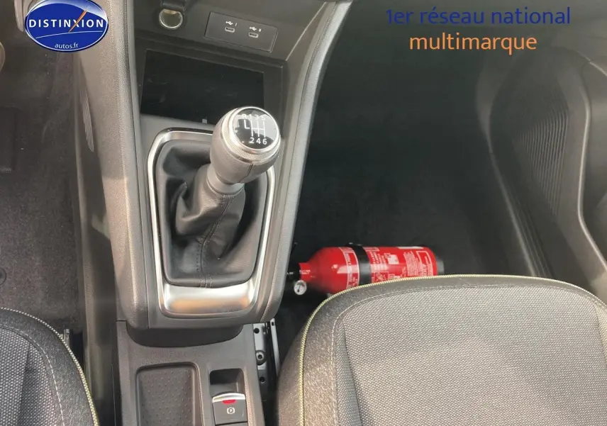Vue intérieure centrée sur la console centrale avec levier de vitesse manuel et siège avant gris du Renault Captur Bleu Iron.
