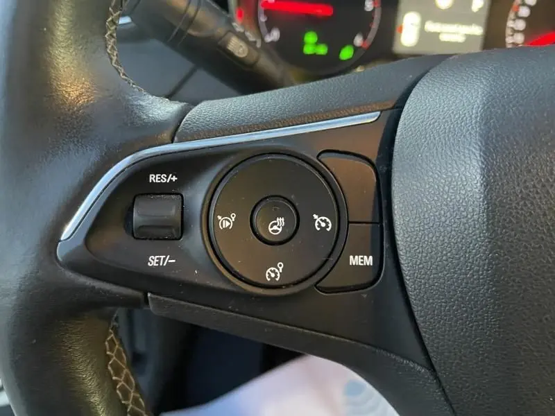 Gros plan sur les commandes du volant noir de l'Opel Grandland X 2019, avec boutons de régulateur de vitesse et mémoire.