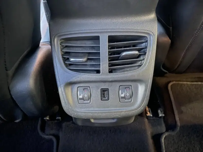 Vue rapprochée de la console arrière noire de l’Opel Grandland X 2019 avec aérateurs, commandes de sièges chauffants et port USB.