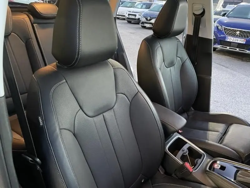 Vue intérieure rapprochée des sièges avant en cuir noir de l’Opel Grandland X 2019, avec porte ouverte côté droit.