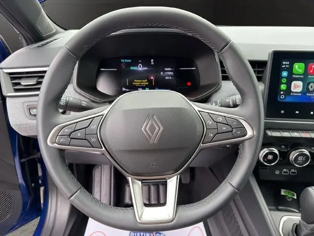 Volant textile grainé de Renault Clio V E-Tech Bleu Iron, vue frontale centrée sur commandes et tableau de bord numérique.