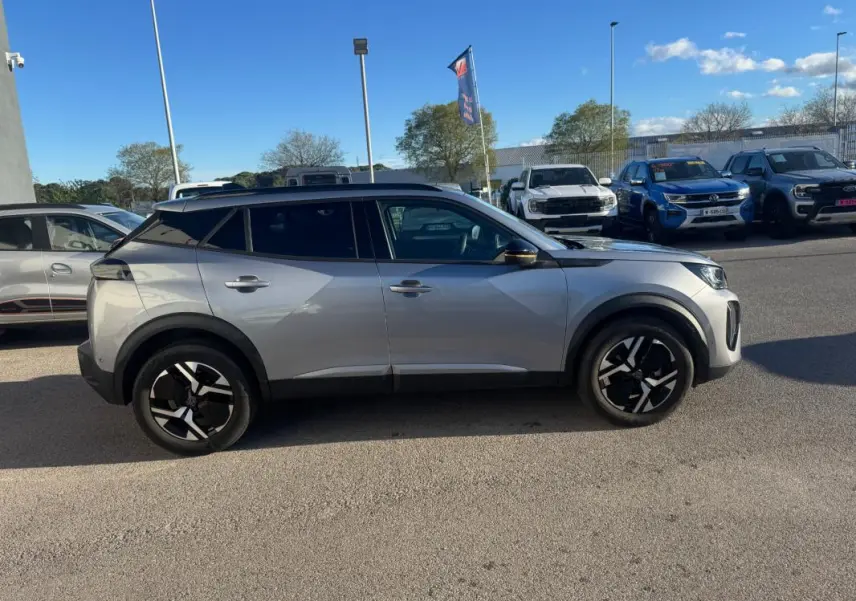 Peugeot 2008 Hybrid gris vue de profil côté gauche, avec jantes alliage 17 pouces et barres de toit noires.