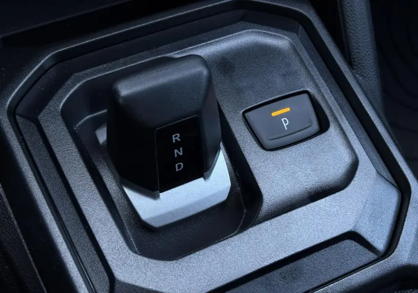 Gros plan sur la commande de boîte automatique et bouton parking du Dacia Duster gris Schiste 2026 intérieur.