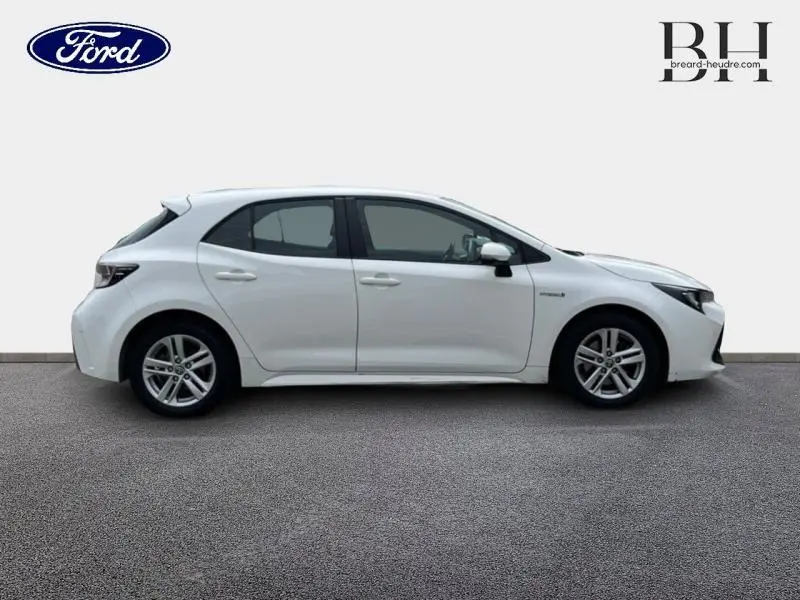 Profil côté gauche d'une Toyota Corolla blanche Pure 2022, compacte et moderne sur fond neutre.