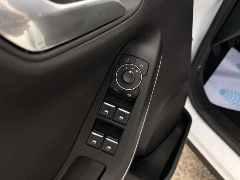 Vue rapprochée des commandes de vitres et rétroviseurs sur la porte côté conducteur d’un Ford Puma blanc 2026.