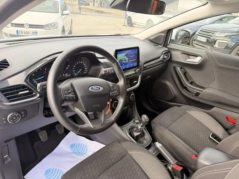 Vue intérieure côté conducteur du Ford Puma blanc 2026, avec volant multifonction, écran tactile et boîte manuelle visible.