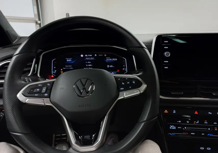 Vue intérieure centrée sur le volant multifonction noir du Volkswagen T-Roc 2025 avec tableau de bord numérique.