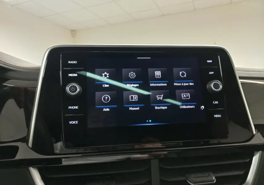 Vue intérieure centrée sur l'écran tactile du tableau de bord du Volkswagen T-Roc 2025, finition R-Line.