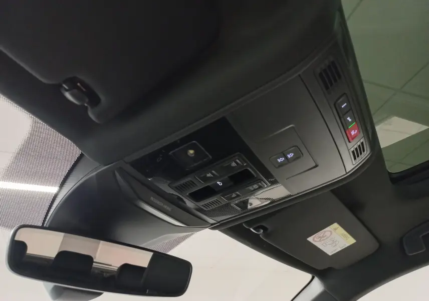 Vue intérieure du toit ouvrant panoramique électrique du Volkswagen T-Roc 2025 noir intense, avec commandes intégrées au plafond.