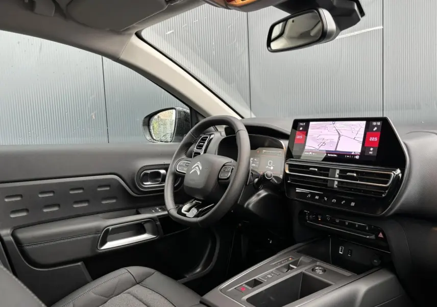 Intérieur noir du Citroën C5 Aircross 2025 vu côté conducteur, avec tableau de bord numérique et écran tactile GPS.