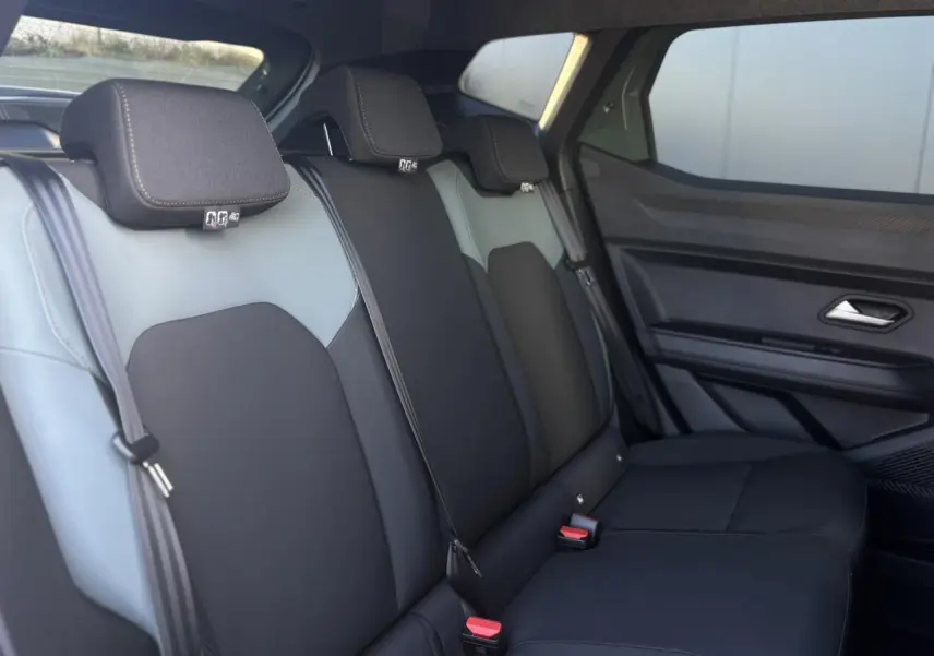 Vue latérale droite de la banquette arrière noire et grise du Dacia Duster 2026 avec ceintures et appuie-têtes intégrés.