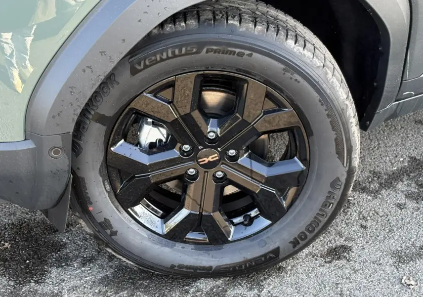Gros plan sur la jante alliage noire 17 pouces du Dacia Duster kaki, avec pneu Hankook Ventus Prime 4 visible.