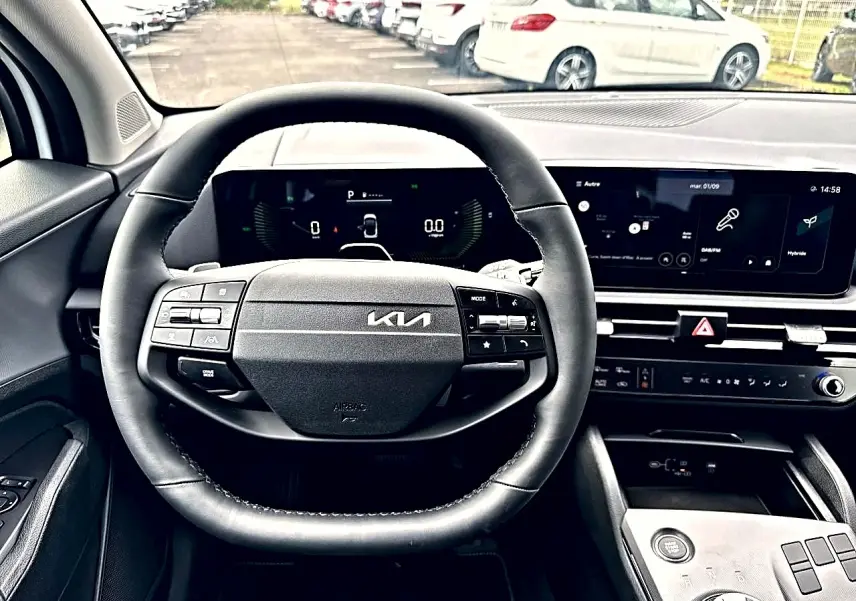 Vue intérieure centrée sur le volant cuir multifonction et le tableau de bord numérique du Kia Sportage blanc 2026.