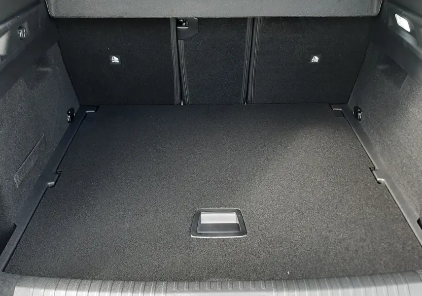 Coffre ouvert vu de face du Peugeot 3008 gris titane, montrant un espace de rangement propre et bien fini.