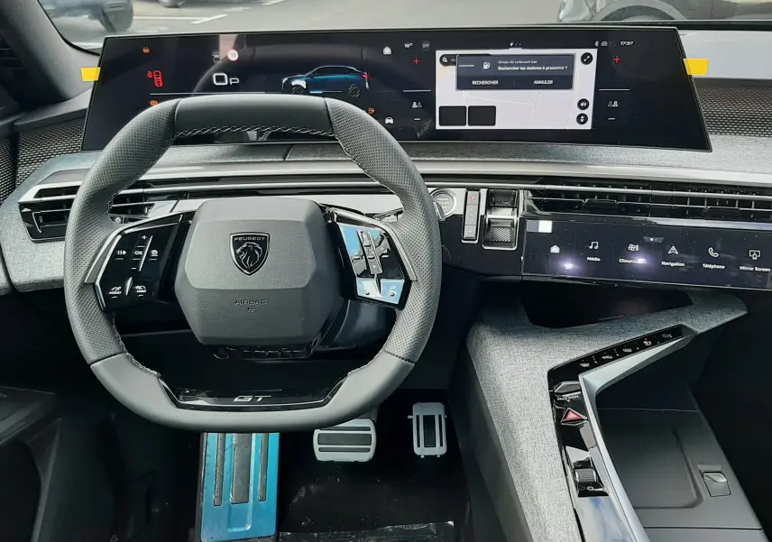 Vue intérieure du poste de conduite du Peugeot 3008 gris titane, avec volant compact GT et double écran tactile panoramique.