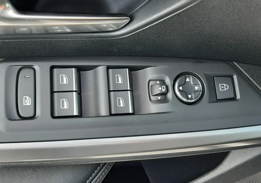 Gros plan sur les commandes de porte côté conducteur du Peugeot 3008 gris titane, avec boutons de vitres et réglage des rétroviseurs.