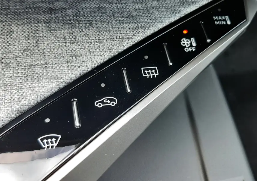 Détail de la console centrale du Peugeot 3008 1.2 Hybrid 145ch GT, boutons de commande du chauffage et ventilation.