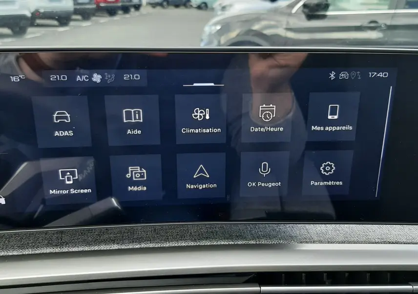 Vue intérieure du tableau de bord du Peugeot 3008 hybride 2026, avec écran tactile affichant les options de climatisation et navigation.