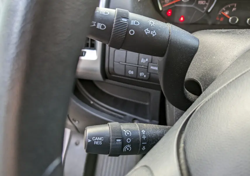 Gros plan sur les commandes de clignotants et régulateur de vitesse du tableau de bord d’un Fiat Ducato blanc de 2019.