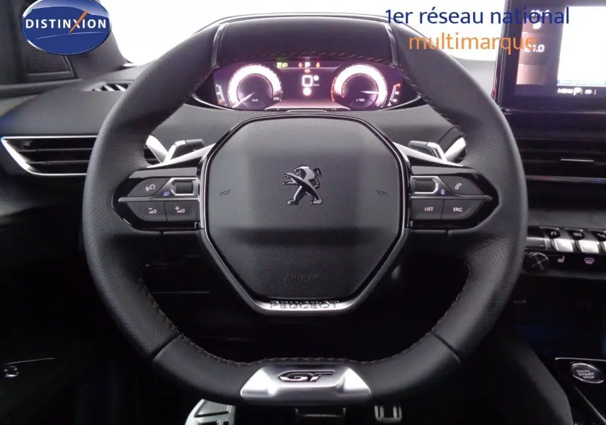 Vue rapprochée du volant cuir noir GT du Peugeot 3008 2023 avec tableau de bord numérique illuminé.