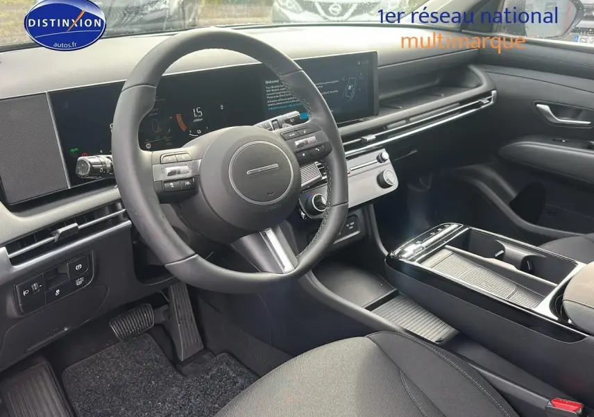 Intérieur moderne du Hyundai Tucson 2025, vue côté conducteur sur le volant cuir et la console centrale noire.