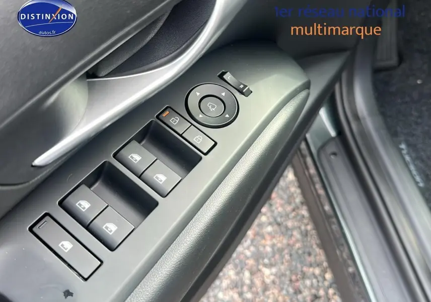 Détail des commandes des vitres et rétroviseurs côté conducteur du Hyundai Tucson vert cyprès 2025.