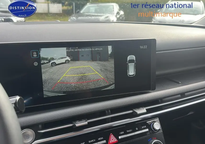 Écran tactile intérieur montrant la caméra de recul d'un Hyundai Tucson vert cyprès en stationnement arrière.