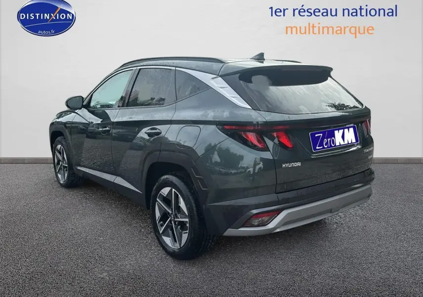 Vue 3/4 arrière droite du Hyundai Tucson 2025 vert cyprès avec jantes alliage et barres de toit visibles.