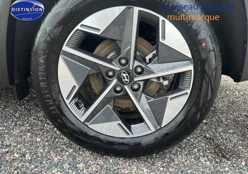 Gros plan sur la jante alliage 18 pouces du Hyundai Tucson vert cyprès, avec logo Hyundai au centre.