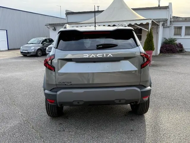 Vue arrière d'un Dacia Duster 1.8 Hybrid 155 Journey gris schiste, avec logo DACIA en grand sur le hayon.