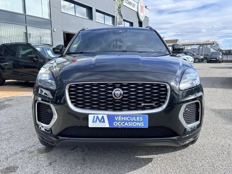 Jaguar E-PACE noir vue de face, mettant en valeur la calandre distinctive et les phares LED, sur parking extérieur.