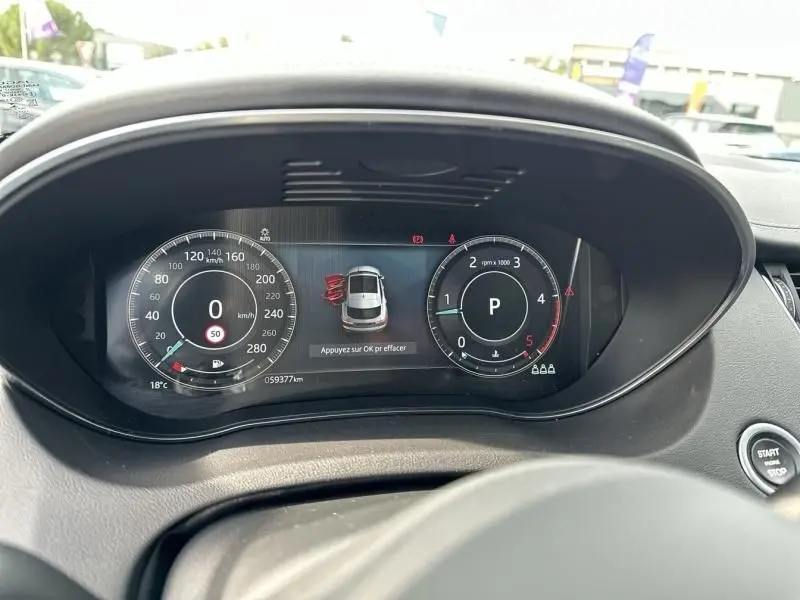 Vue rapprochée du tableau de bord numérique noir du Jaguar E-PACE 2021, affichant vitesse, régime et alertes.