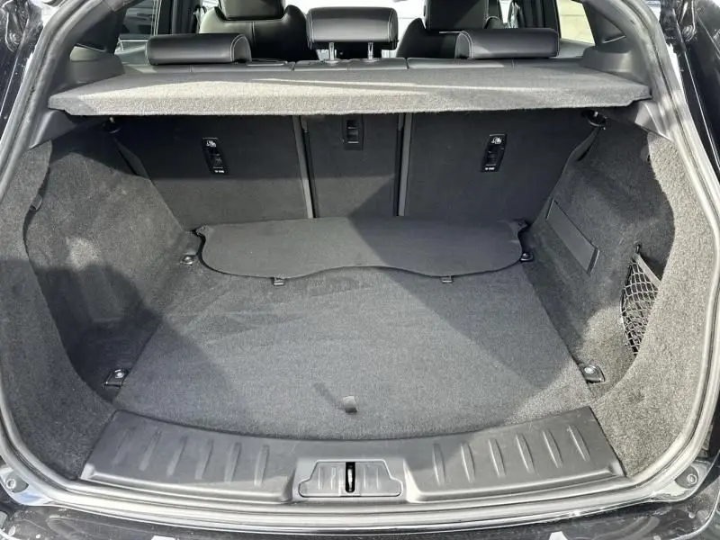 Vue arrière du coffre ouvert du Jaguar E-PACE noir 2021, montrant un espace de chargement propre et bien agencé.