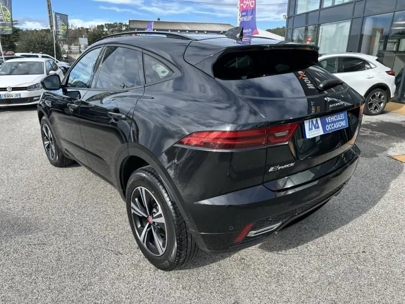 Jaguar E-PACE noir vue 3/4 arrière droit, avec feux arrière fins et jantes alliage, stationné en extérieur.