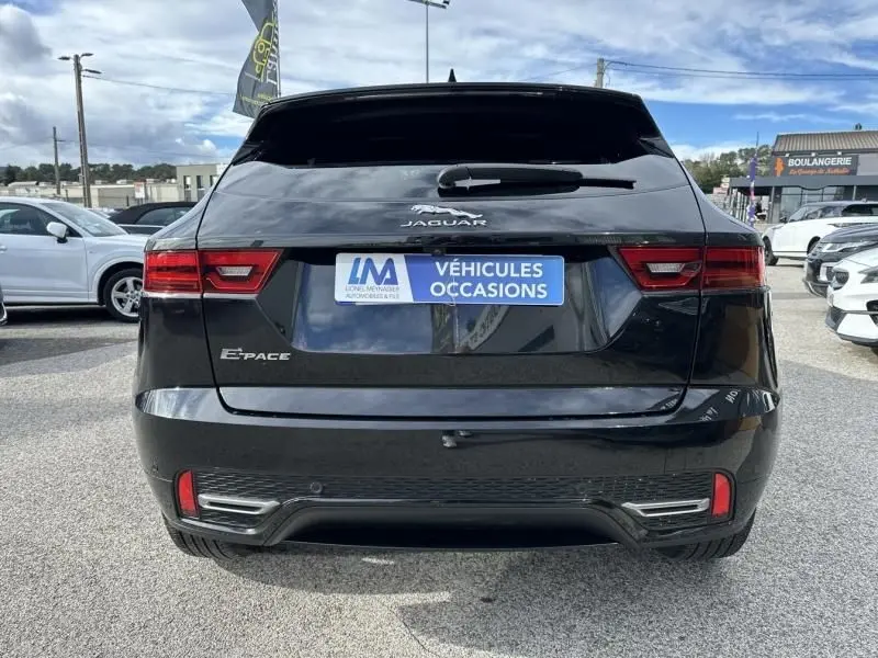 Vue arrière d'un Jaguar E-PACE noir 2021, version D165 MHEV R-DYNAMIC S avec feux arrière LED et logo Jaguar visible.
