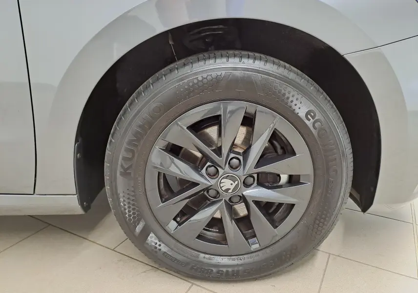 Gros plan sur la roue avant gauche d'une Skoda Fabia 2025 gris graphite avec jante alliage noire 15 pouces.