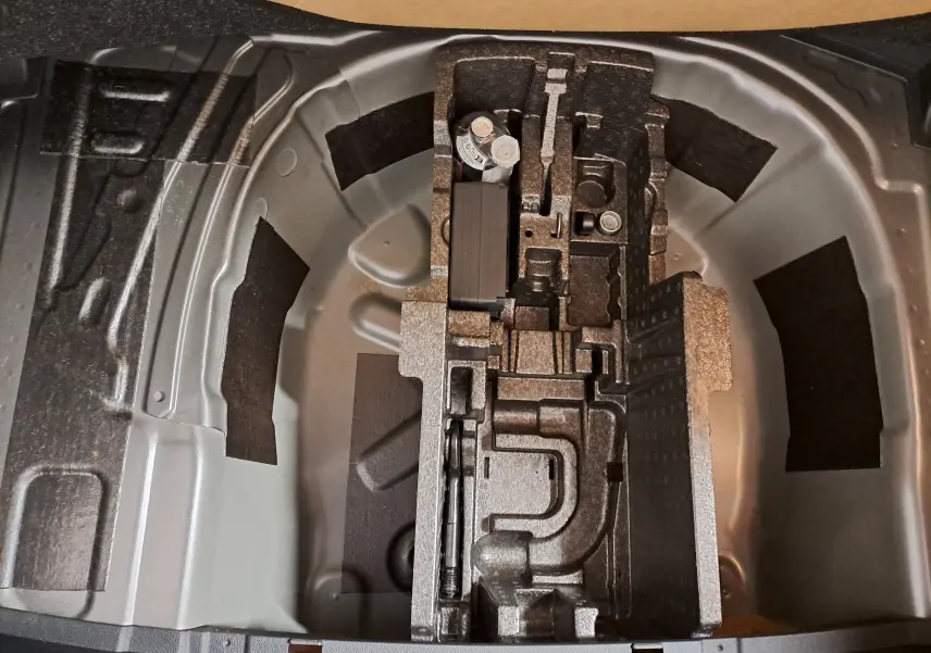 Vue plongeante sur le rangement sous coffre d'une Skoda Fabia 2025, montrant l'emplacement pour roue de secours et outils.