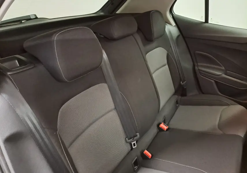 Vue intérieure de la banquette arrière de la Skoda Fabia 2025, sièges tissu gris et noir avec ceintures visibles.