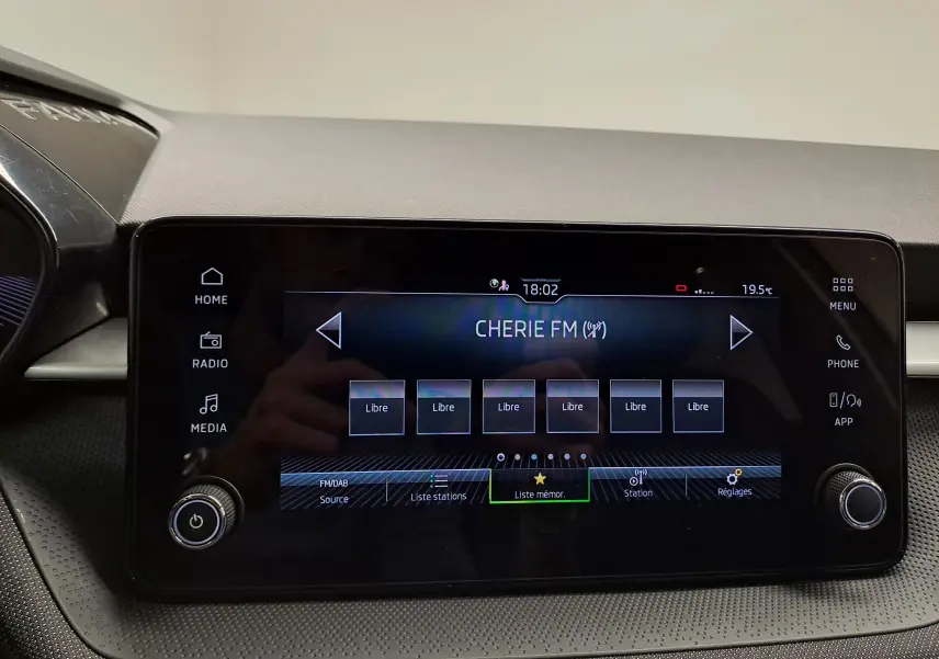 Écran tactile central du tableau de bord de la Skoda Fabia 2025 affichant la radio Cherie FM, avec commandes tactiles et boutons rotatifs.