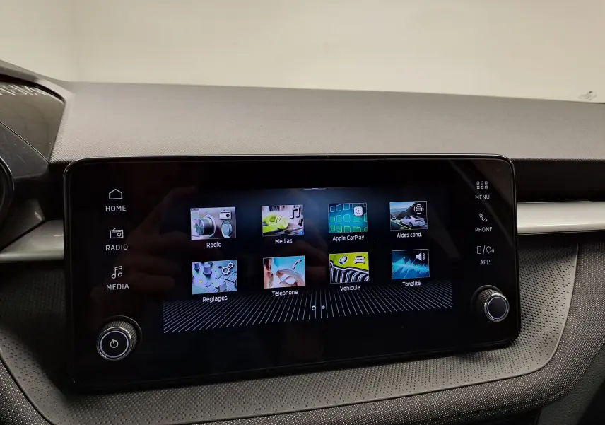 Écran tactile central de la Skoda Fabia 2025 affichant les menus radio, médias, Apple CarPlay et aides à la conduite.