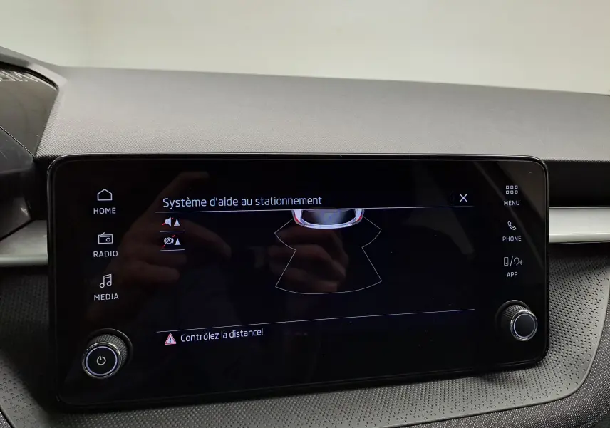 Écran tactile intérieur du Skoda Fabia 2025 montrant le système d'aide au stationnement avec commandes autour.