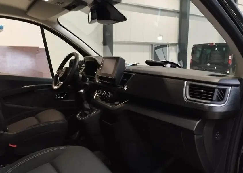 Vue intérieure côté conducteur du Nissan Primastar noir 2025, avec tableau de bord moderne et écran tactile central.