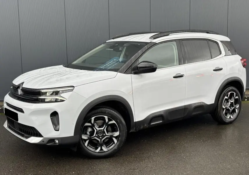 SUV Citroën C5 Aircross blanc Okénite en 3/4 avant droit, avec jantes alliage bi-ton et barres de toit noires.