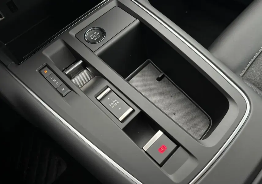 Gros plan sur la console centrale noire du Citroën C5 Aircross 2025 avec bouton start/stop et commandes de boîte auto.